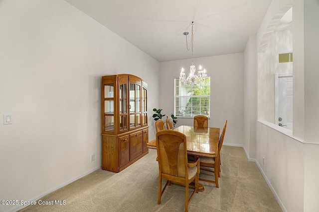 dining room featuring baseboards, an inviting chandelier, and light colored carpet