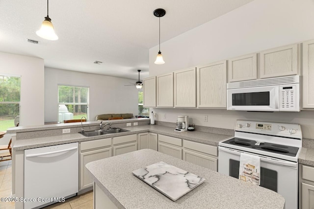 kitchen with light tile patterned floors, a peninsula, white appliances, a sink, and light countertops