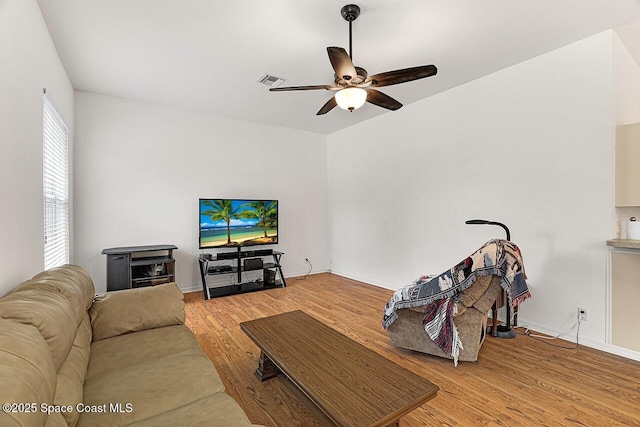 living room with visible vents, ceiling fan, baseboards, and wood finished floors