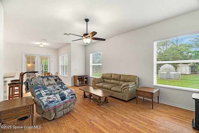 living area with ceiling fan, visible vents, baseboards, french doors, and light wood finished floors