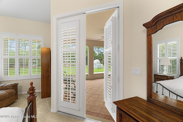 entryway with carpet, a healthy amount of sunlight, baseboards, and tile patterned floors