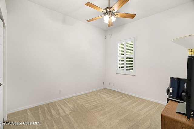 interior space featuring light carpet, baseboards, and a ceiling fan