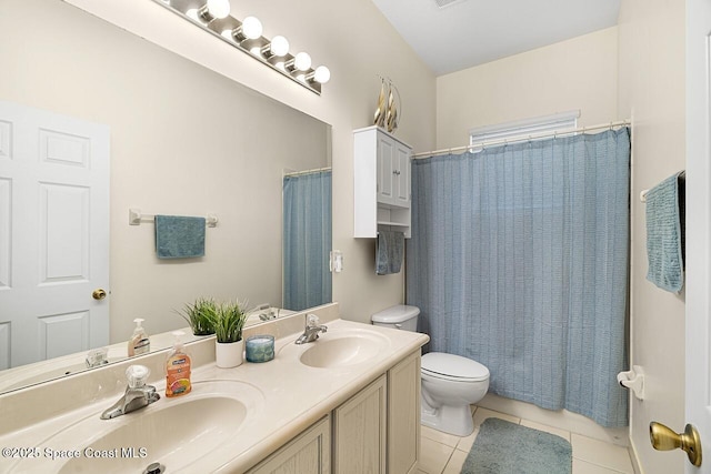 full bath featuring toilet, double vanity, a sink, and tile patterned floors