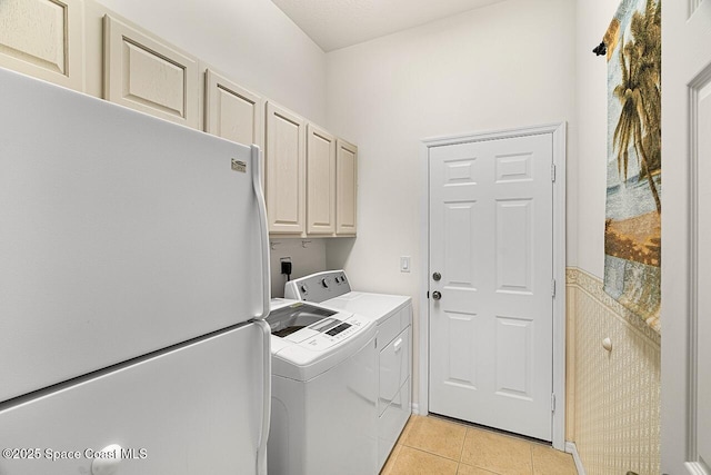 washroom with light tile patterned floors, cabinet space, and separate washer and dryer