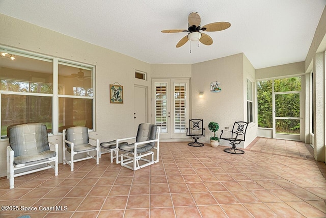 sunroom featuring ceiling fan and french doors