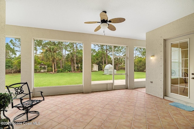 unfurnished sunroom with plenty of natural light and ceiling fan