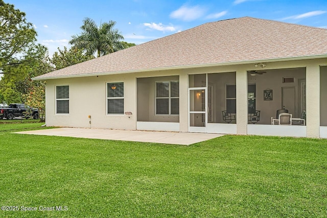 rear view of property featuring a shingled roof, a sunroom, a yard, stucco siding, and a patio area