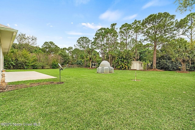 view of yard with an outbuilding, a patio area, and a storage shed