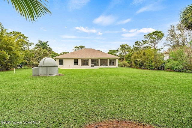 rear view of property with a yard and stucco siding