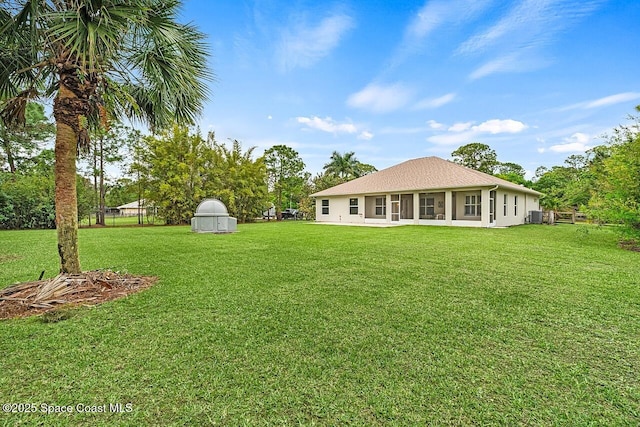 back of house with a lawn and stucco siding