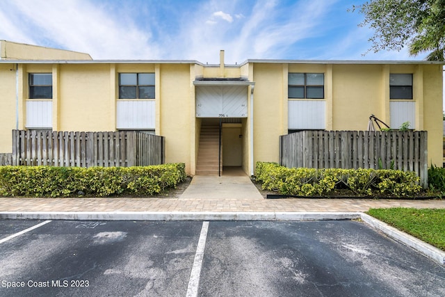 view of property with uncovered parking and fence