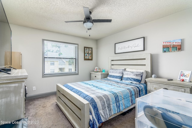 carpeted bedroom featuring a ceiling fan, baseboards, and a textured ceiling