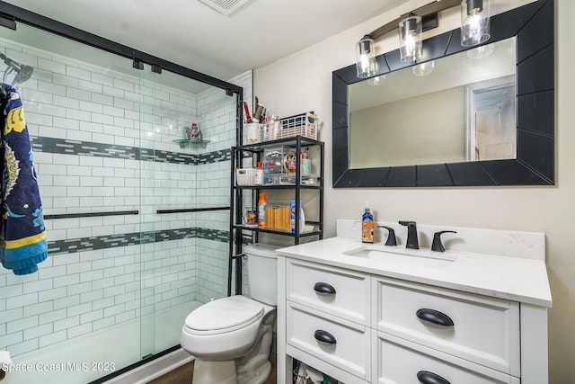 bathroom with toilet, a shower stall, and vanity