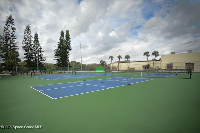 view of tennis court with community basketball court and fence