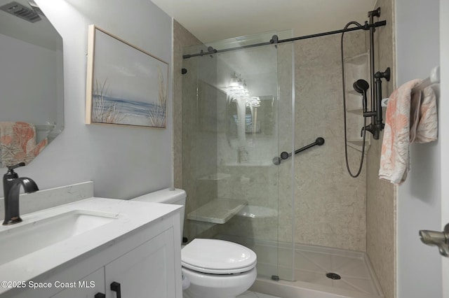 bathroom with toilet, a stall shower, and vanity