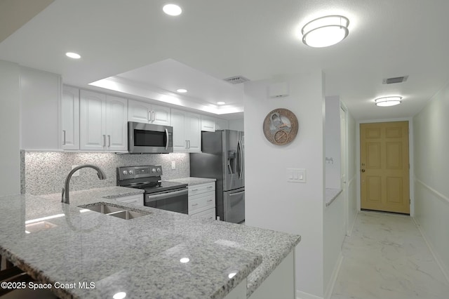 kitchen with stainless steel appliances, a sink, white cabinets, marble finish floor, and light stone countertops