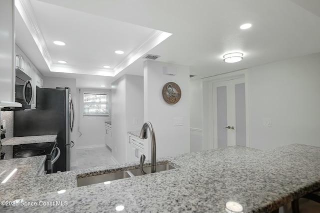 kitchen with electric stove, stainless steel microwave, light stone counters, and a sink