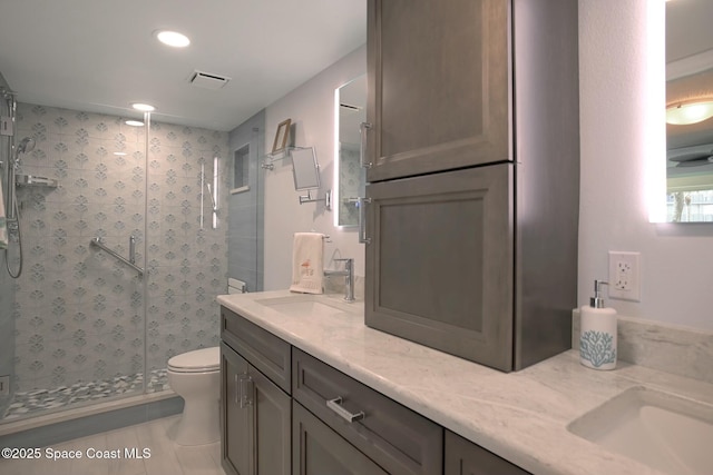 full bath featuring toilet, a sink, visible vents, a shower stall, and double vanity