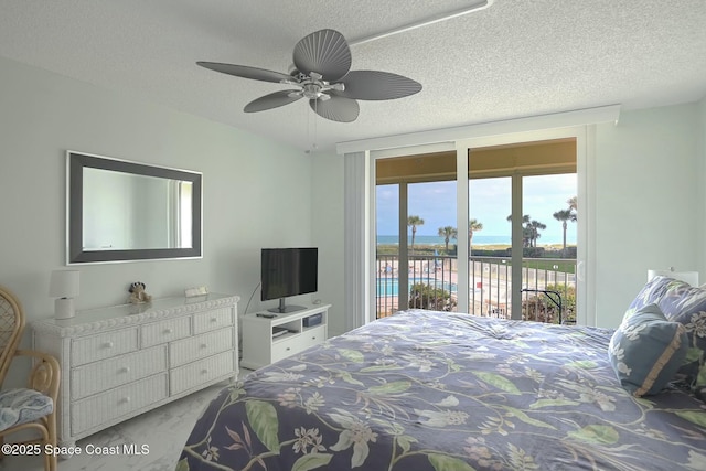 bedroom with access to exterior, a textured ceiling, and a ceiling fan