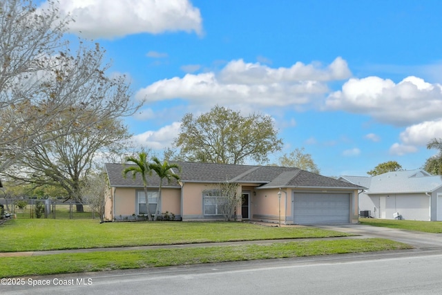 ranch-style home with a garage, fence, concrete driveway, stucco siding, and a front yard