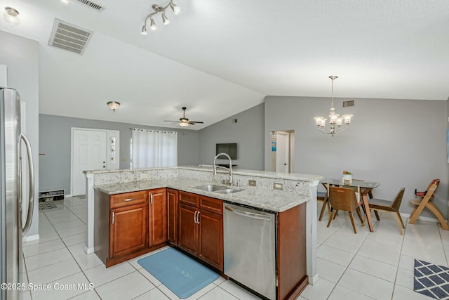 kitchen with light tile patterned flooring, a sink, visible vents, vaulted ceiling, and appliances with stainless steel finishes