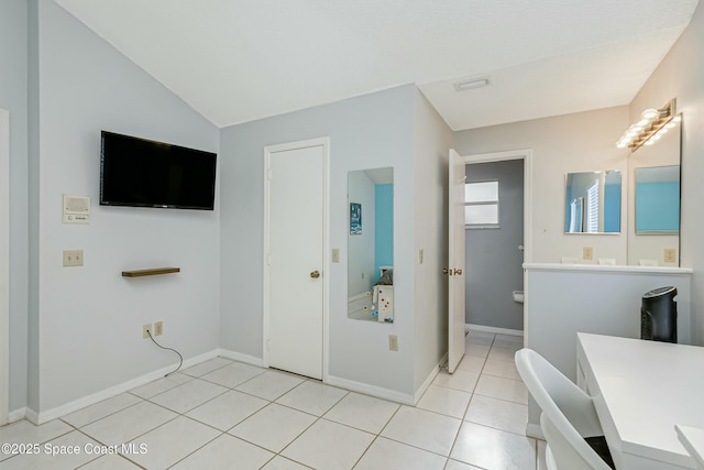 bathroom with baseboards, vaulted ceiling, and tile patterned floors