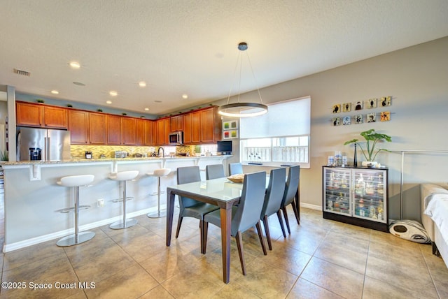 dining room featuring light tile patterned floors, baseboards, visible vents, a textured ceiling, and recessed lighting