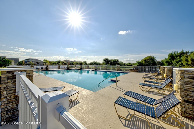 community pool featuring a patio and fence