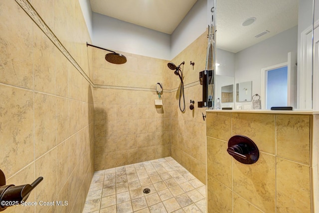 bathroom featuring tiled shower and visible vents