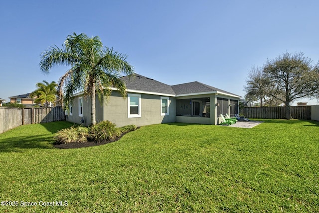 back of property featuring a lawn, a fenced backyard, a sunroom, and stucco siding