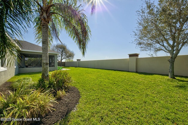 view of yard featuring a sunroom and a fenced backyard