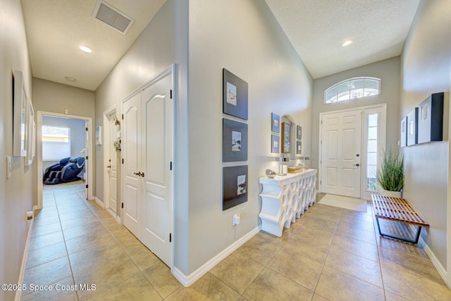 entrance foyer with recessed lighting, visible vents, light tile patterned flooring, a textured ceiling, and baseboards