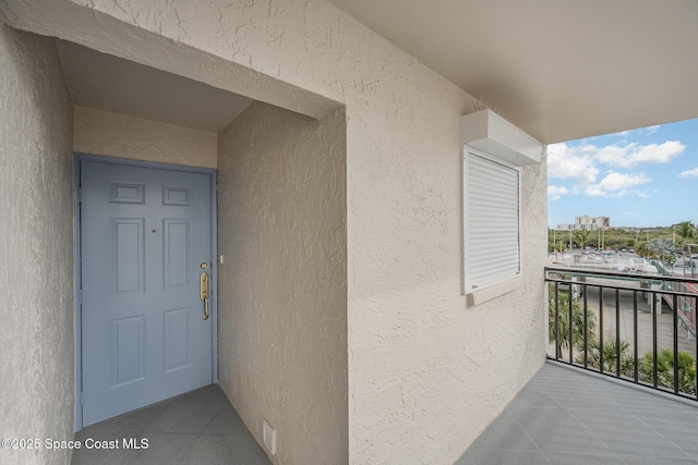 doorway to property featuring a balcony and stucco siding