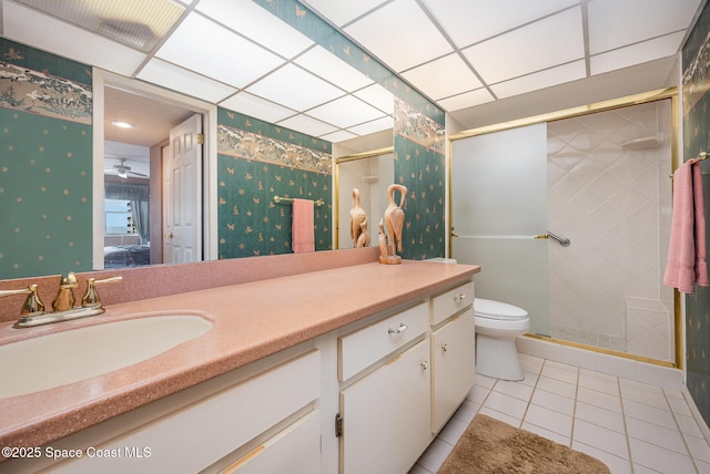 ensuite bathroom with toilet, vanity, a shower stall, tile patterned floors, and wallpapered walls