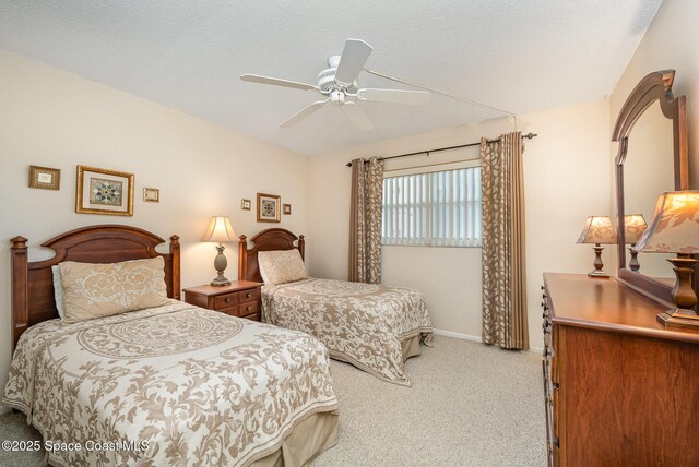 carpeted bedroom featuring a textured ceiling, baseboards, and a ceiling fan