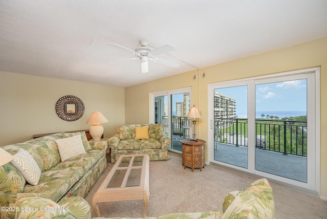 carpeted living area with ceiling fan