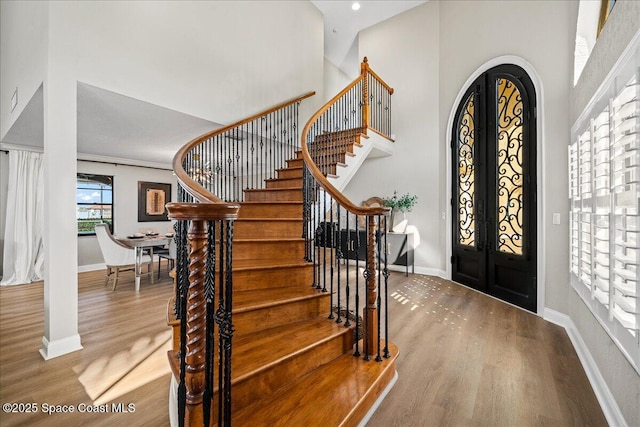 entryway featuring stairway, wood finished floors, and baseboards