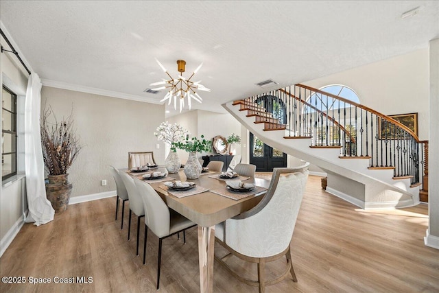 dining area featuring stairway, plenty of natural light, and wood finished floors