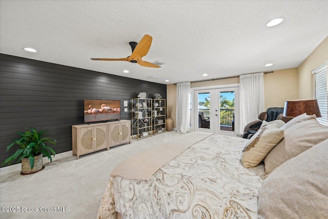 carpeted bedroom with access to exterior, visible vents, french doors, a textured ceiling, and a ceiling fan