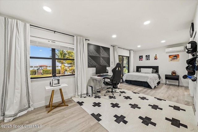 bedroom with recessed lighting, wood finished floors, and a wall mounted air conditioner