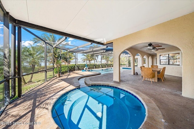 outdoor pool featuring a patio, an in ground hot tub, a lanai, and ceiling fan