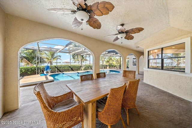 view of patio with a lanai, a ceiling fan, and an outdoor pool