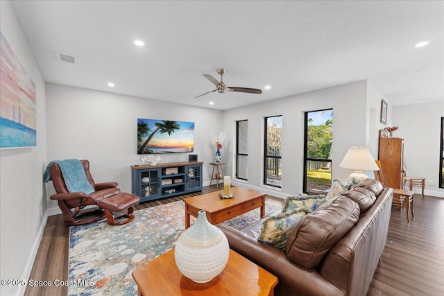 living area featuring baseboards, visible vents, wood finished floors, and recessed lighting