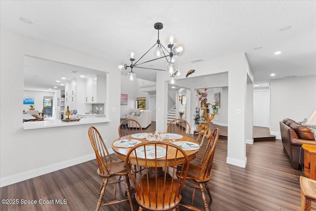 dining room featuring baseboards, stairway, an inviting chandelier, and wood finished floors