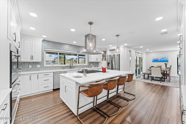 kitchen featuring island exhaust hood, stainless steel appliances, light countertops, visible vents, and white cabinetry