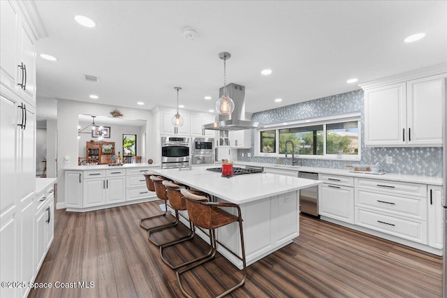 kitchen featuring appliances with stainless steel finishes, white cabinetry, a sink, and island range hood