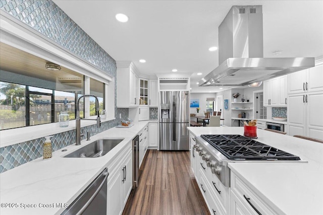 kitchen featuring recessed lighting, appliances with stainless steel finishes, white cabinets, a sink, and island range hood