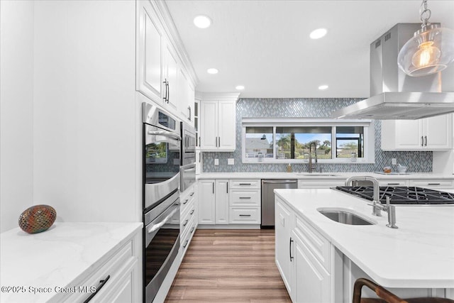 kitchen featuring stainless steel appliances, white cabinetry, island exhaust hood, and light wood finished floors