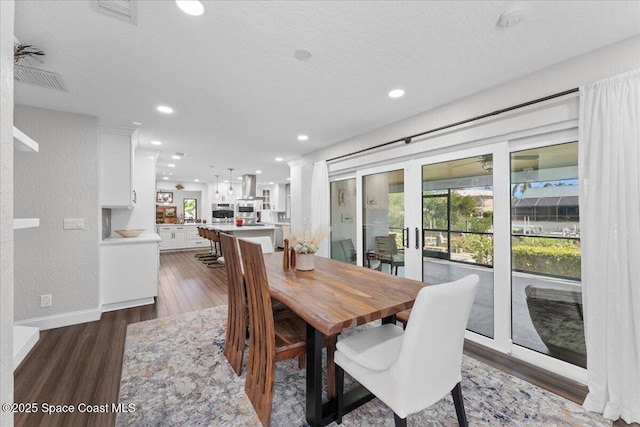 dining room with baseboards, visible vents, wood finished floors, a textured ceiling, and recessed lighting