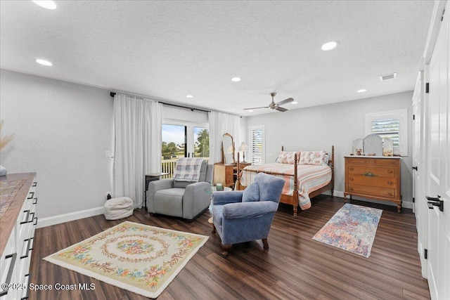 bedroom with a textured ceiling, dark wood-style floors, visible vents, and baseboards